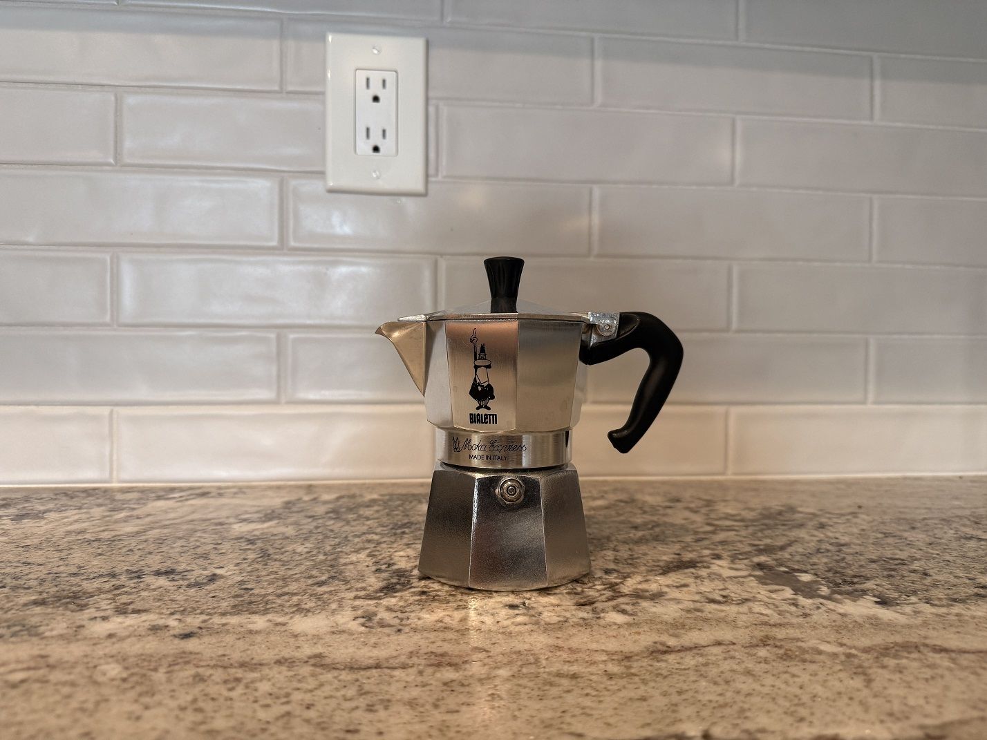 The Bialetti Moka Express 3-cup against a tiled kitchen backsplash.